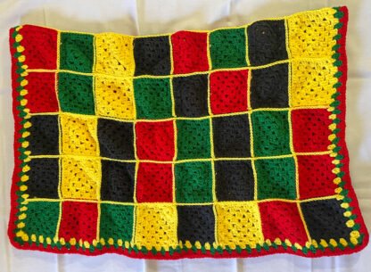 red, black, yellow granny square blanket folded in half