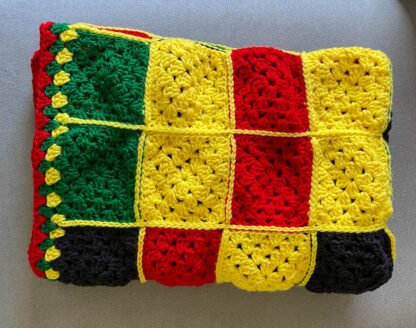 red, black, yellow granny square blanket folded in half 3 times
