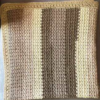 coffee and cream v-stitch crochet blanket folded in half twice laid on chaise lounge