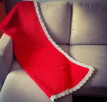 red vstitch blanket with Gray Shell border draped over couch